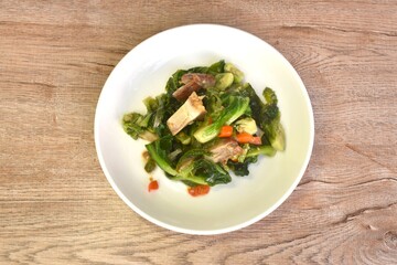 fried Brussels sprout or baby cabbage and crispy pork with soy sauce on plate 