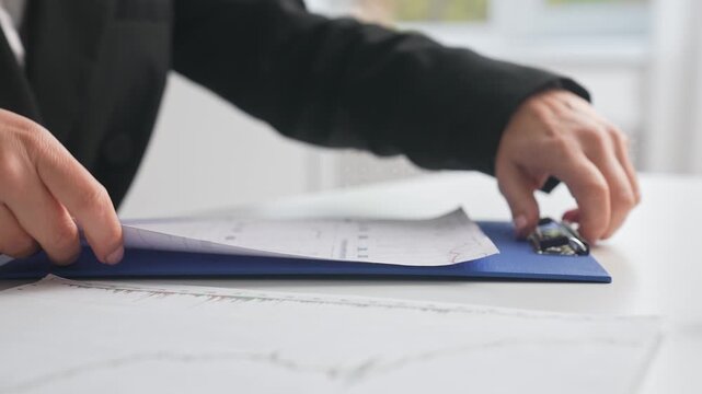 Hands Organizing Documents on Office Desk