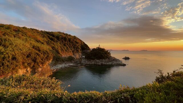 Sheltered coastal cove under a warm evening sky