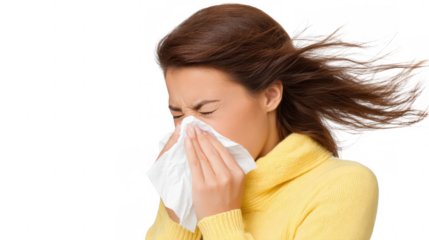 Young man with an afro, wearing a scarf, sneezing into a tissue while battling a cold or allergies, isolated against a transparent background, expressing discomfort and illness