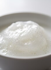Close Up Of White Foam Bubbles In A Bowl With Soft Lighting And A White Background