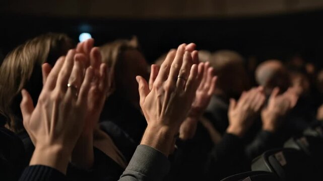 Woman and other audience members clapping hands during a performance. Applause, appreciation, and ovation at a concert or show.