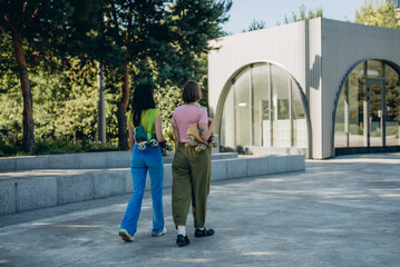 Pretty young women walk in sync swinging arms after roller skates training
