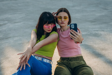 Young women with quad skates take selfie on smartphone on sports ground