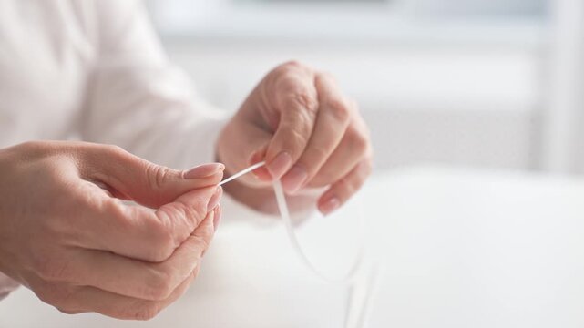 Hands Holding White Cable Tie in Home Setting