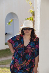 Mulher madura com chap&eacute;u e roupas descontra&iacute;das em ambiente de ferias. 