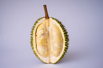 Fototapeta premium Premium shot of a halved durian fruit, revealing rich creamy yellow pulp and a sharp spiky husk. Fresh tropical exotic fruit isolated on a plain white background