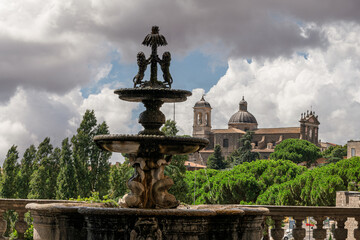 Fototapeta premium Italy - Viterbo - Palazzo dei Priori terrace - Baroque fountain with dolphins facing cathedral domes across green canop
