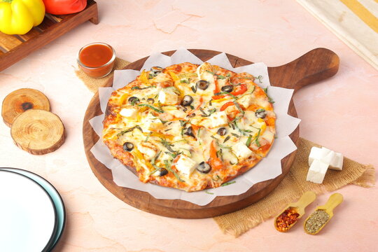 Freshly baked paneer and veggie pizza topped with soft paneer cubes, colorful vegetables, melted cheese, and a crispy crust. A popular fusion dish combining Indian flavors with classic pizza style, pe