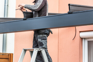 Workers install patio roofing with steel and glass