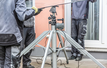 Workers install patio roofing with steel and glass