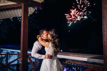 A newlywed couple watches a wedding fireworks display against