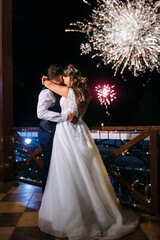 A newlywed couple watches a wedding fireworks display against