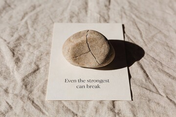 Even the strongest can break a cracked stone on a paper with inspirational quote