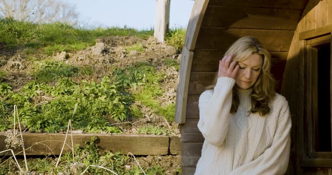 Attractive happy middle aged woman in her forties outside thoughtful, sad or depressed in golden winter sunshine