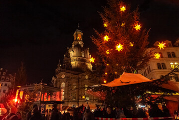 Christmas in Dresden, Saxony, Germany. View of the Frauenkirche and a Christmas tree decorated with Christmas stars.