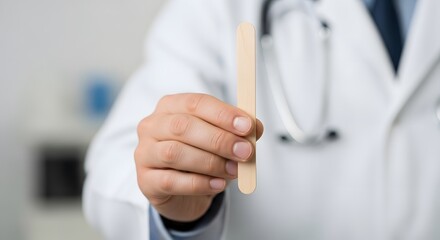 Doctor Holding Wooden Tongue Depressor Close-Up