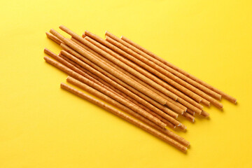 Cracker sticks on yellow background close up