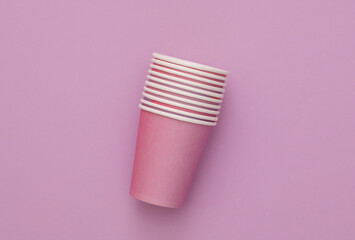 Paper disposable cups for birthday party on purple background