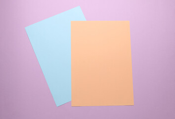 Fototapeta premium Sheets of colored paper on a purple pastel background