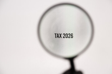 Tax 2026 on the monitor screen through a magnifying glass