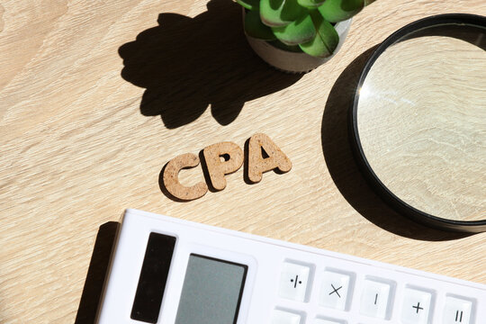 Word CPA up on the table with office accessories. Business concept. Top view