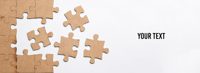 Wooden pieces jigsaw puzzle on white background with copy space