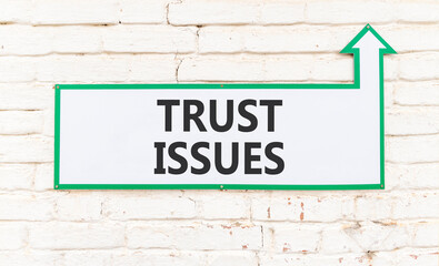 Obraz premium Trust issues symbol. Concept word Trust issues on beautiful white sign on white brick wall. Beautiful white brick wall background. Business trust issues concept. Copy space.