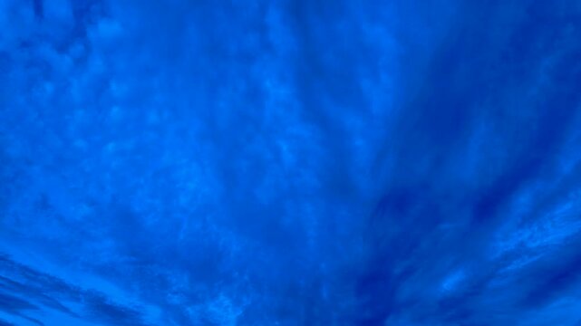 Vibrant blue sky with swirling cloud formation captured in a timelapse shot
