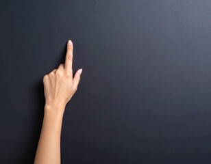 Pointing Hand on Dark Backdrop: A poised hand extends, its index finger sharply directed against a textured, muted background, inviting interaction and symbolizing intent.
