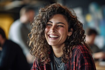 Diverse Tech non binary employee in office or coworking space wearing casual clothes, laughing with colleagues, candid moment. Equity, inclusion  and diversity values at workplace.