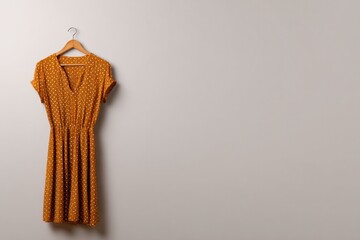 Flowy dress in warm mustard hue showcases playful polka dots, pe