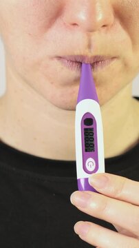 Woman have light high temperature 37 C. Beginning cold. Electronic thermometer. Vertical footage.
