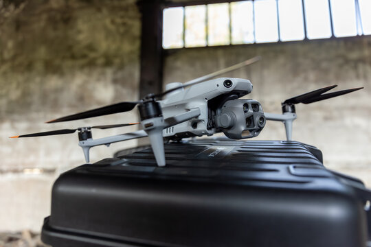 Front view of a DJI Matrice 4T enterprise drone with multi-sensor camera on a transport box in an old building