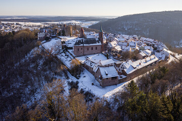 Aerial view of snow-dusted rooftops and ancient stone structures rise from the winter landscape, a historic town nestled in frosted hills, Neckargemund, Baden-Wurttemberg, Germany.