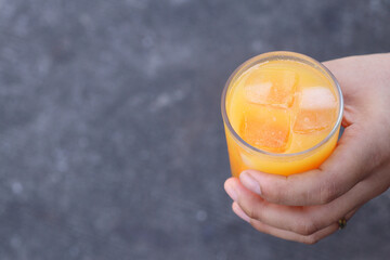 Soft drinks orange juice and iced in glass on hand