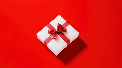 Gift box with red ribbon on red background