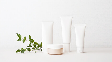 Minimalist skincare product arrangement with white tubes and cream jar on light background