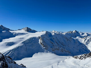 Majestic alpine glacier and rugged mountain ridges under a blue sky in Austria
