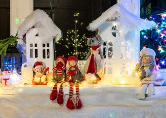 Christmas view from a white cardboard house, various gnome figures, colorful lights, home interior decor, festive mood