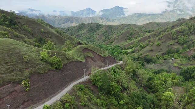 Aerial view of car driving through the fores and the lake on the side. Beautiful mountain road. Driving on the mountain road. Road trip. Mountain forest lake landscape. Car driving through pine forest