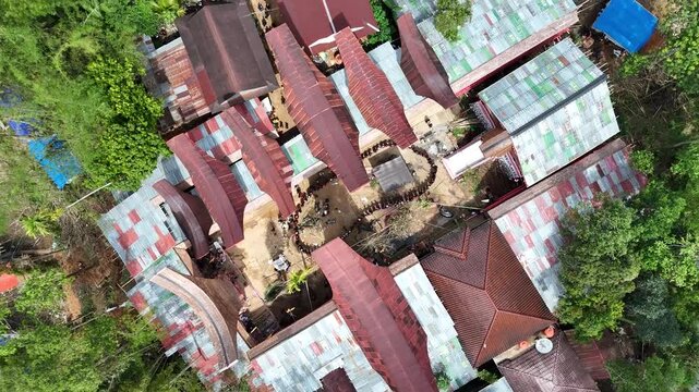 Aerial drone footage capturing the traditional Toraja Rambu Solo ceremony featuring the culturally significant buffalo cutting ritual, documenting the unique funeral tradition and heritage of Toraja