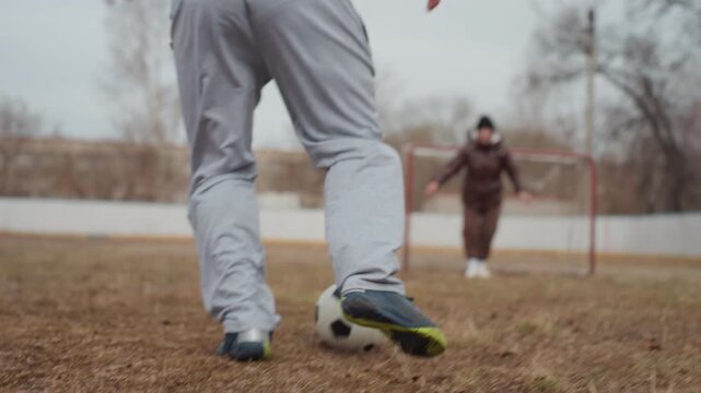 view of game setup on cloudy day, soccer pitch scene showing player movement and tense anticipation, raw perspective of match moment with focused player actions and moody weather conditions