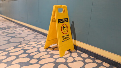 Yellow Caution Tripping Hazard Sign on Carpet