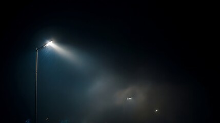 Single street illumination cuts through dense nocturnal atmosphere with visible mist
