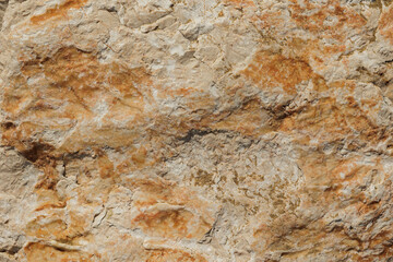 antica superficie naturale di roccia, ruvida e consumata e con leggeri rilievi, dalle sfumature di colore grigio ed arancione