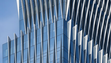 Obraz premium Modern office building with sleek glass facade and blue sky