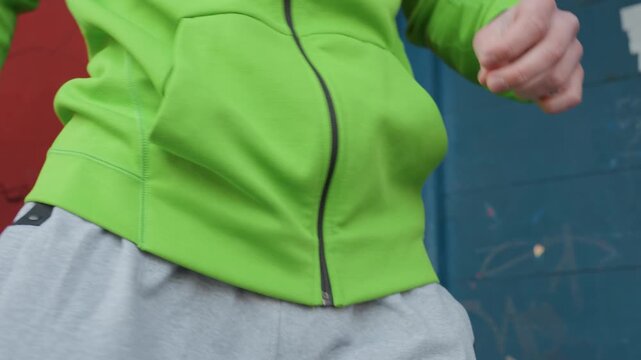 athlete preparing through gentle stretches, individual engaged in light movements dressed in sportswear, athlete in casual outfit performing warmup exercises prior to competition initiation