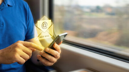 Man using smartphone checking new email notification on train window seat, commuting with digital message alert and blurred landscape view