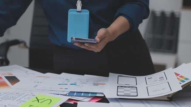 Professional woman working on UXUI design, creating wireframes and mockups for a mobile application while on a call